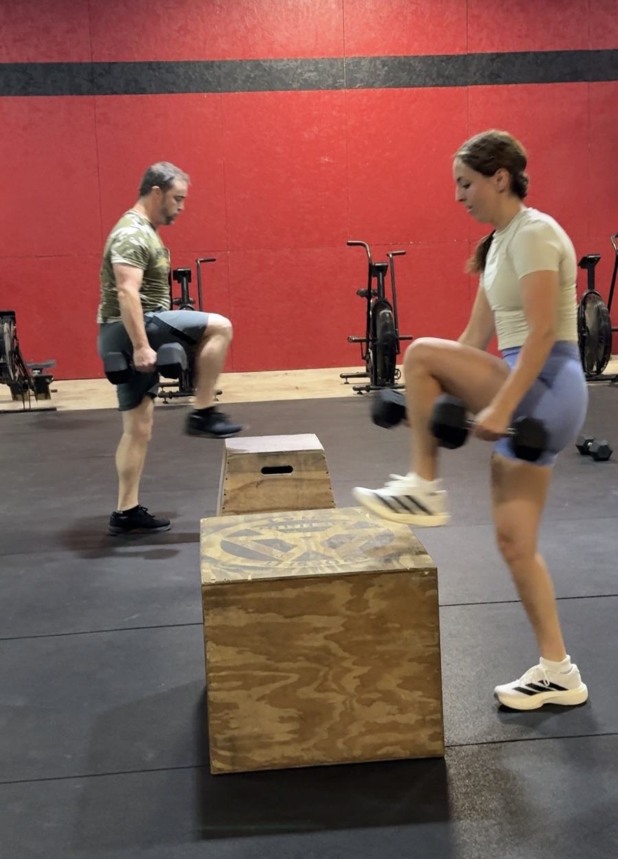 SemperFit athletes performing dumbbell step-ups during a class