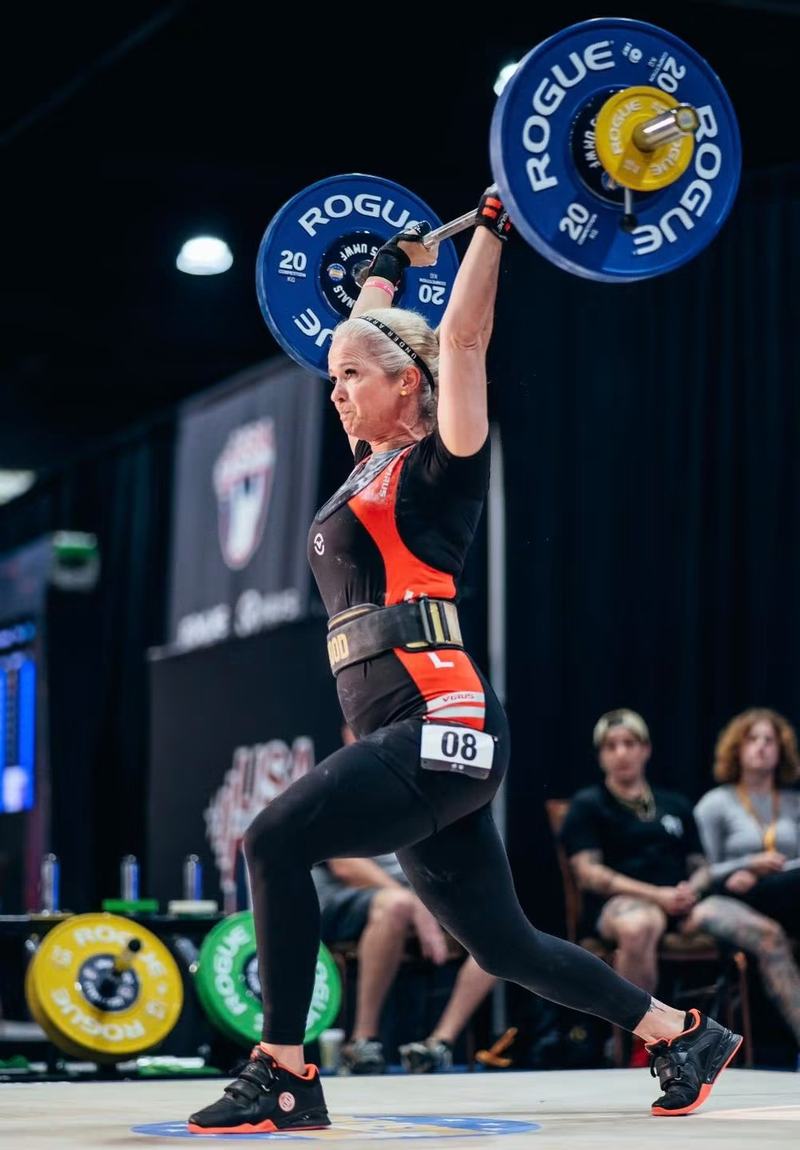 A Vektløfter athlete locking out a jerk at a USA Weightlifting meet