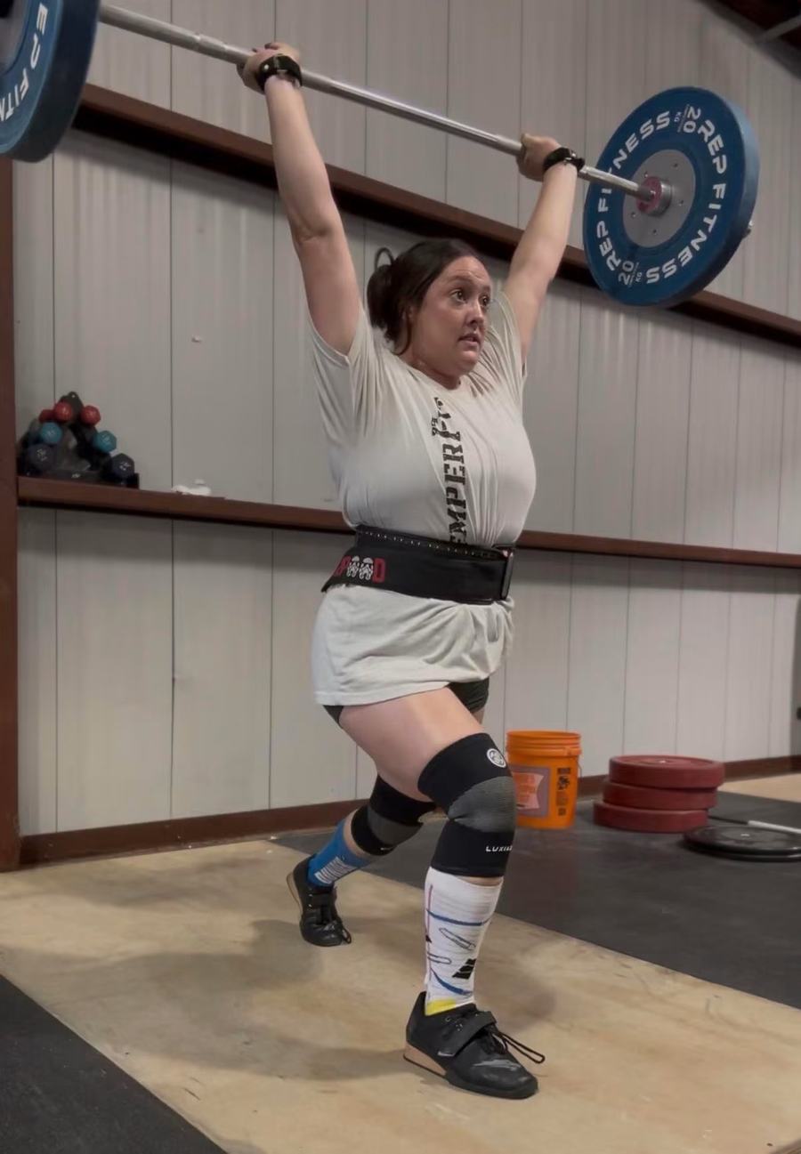 A SemperFit athlete locking out a split jerk overhead
